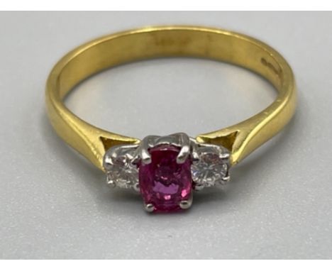 Ladies 18ct gold Ruby and diamond ring. Featuring a oval ruby set with a single round brilliant cut diamond on each side. Siz