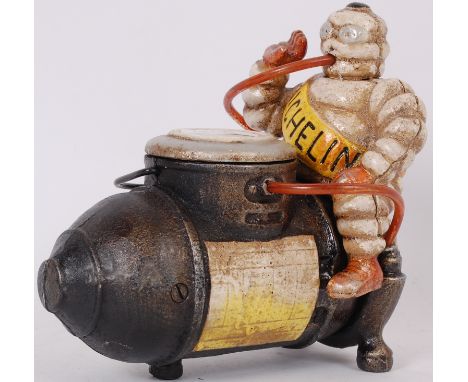 MICHELIN MAN; A vintage style cast iron advertising figure of Bibendum the Michelin Tyres mascot seated upon a model compress