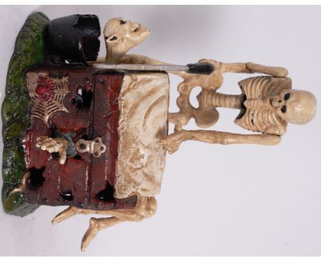 MONEY BOX; A 20th century antique style cast iron clockwork mechanical automaton moneybox depicting a macabre scene of a skel