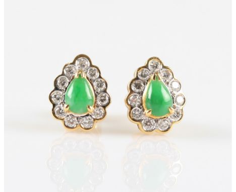 A pair of green jade and diamond cluster stud earrings, each set with a pear cut jade cabochon, surrounded by a border of ele