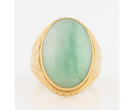 A green jadeite jade ring, set with an oval jadeite cabochon, measuring approx. 22x16mm, metalwork having engraved fan design