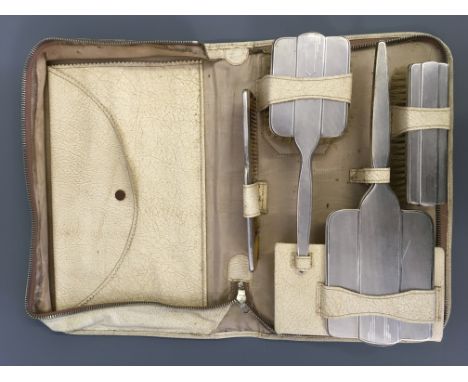 A silver Art Deco cased four piece brush set including a mirror, two brushes and comb, hallmarked Sheffield 1937. IMPORTANT: 