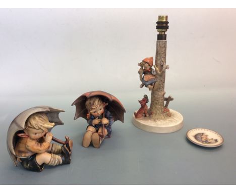 Two Goebel Hummel figurines boy and girl under umbrellas, one Goebel Hummel lamp base and small plate. IMPORTANT: Online view