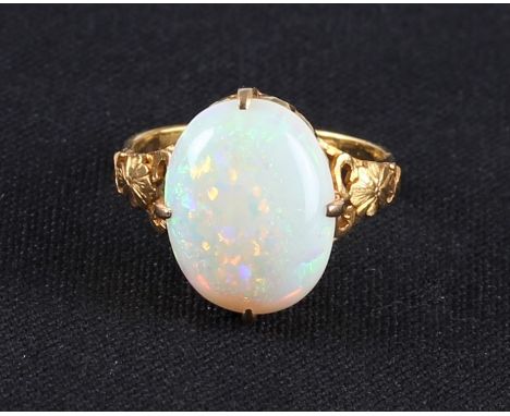 An opal ring, set with an oval opal cabochon, measuring approx. 15x11mm, with open metalwork gallery and floral design should