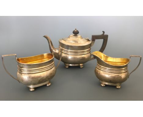 A silver three piece bachelors tea set including tea pot with ebony handle and finial with milk jug and sugar bowl, hallmarke