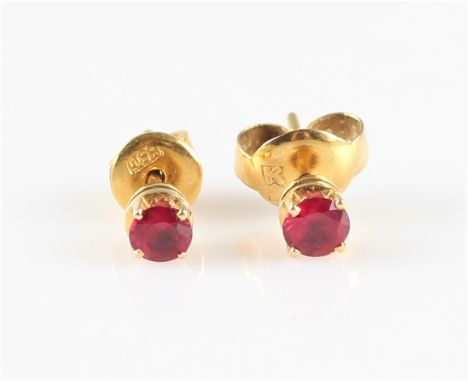 A pair of ruby stud earrings, each set with a round cut ruby, measuring approx. 3mm, unmarked yellow metal. IMPORTANT: Online