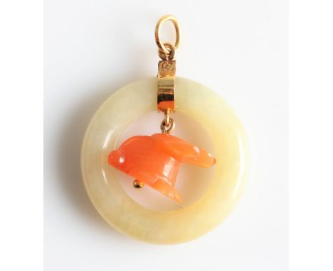 A yellow/green jade and orange hardstone pendant, designed as the yellow/green jade circle surrounding the carved orange hard