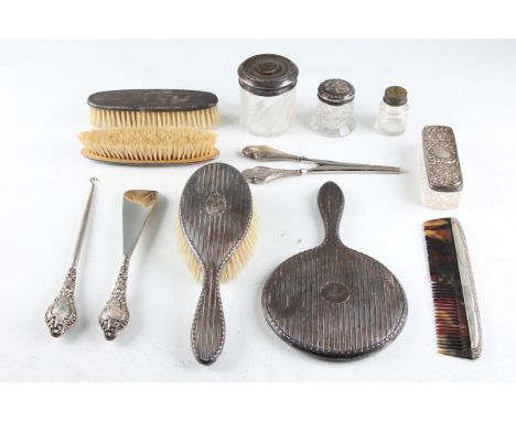 A collection of hallmarked silver dressing table pieces, to include a comb, a shoe horn, a button hook, three storage jars, t