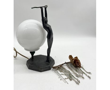 An Art Deco metal table lamp in the form of a nude female with arms outstretched, marked "British Made" to the back