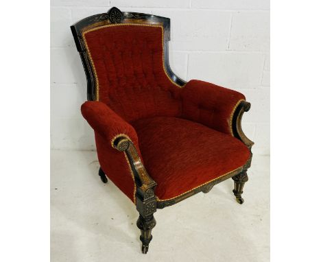 An Empire ebonised arm chair with button back detailing