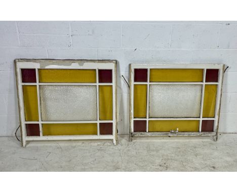 A pair of vintage sash windows with red and green coloured glass panels. 
