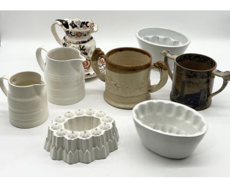 A collection of various antique china including loving cup decorated with views of Taunton, three jelly moulds including Shel