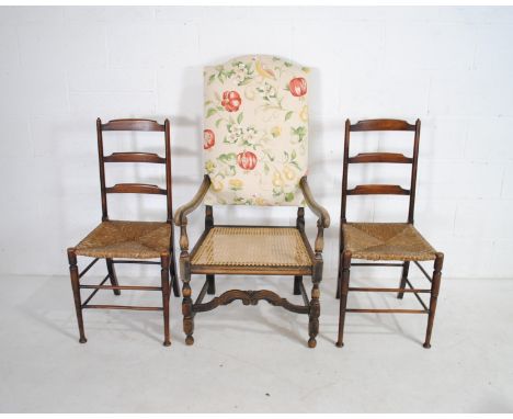 A turn of the century armchair along with a pair of rush seated ladder back chairs
