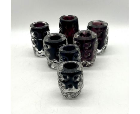 A collection of seven Liskeard Glass purple art glass vases. 