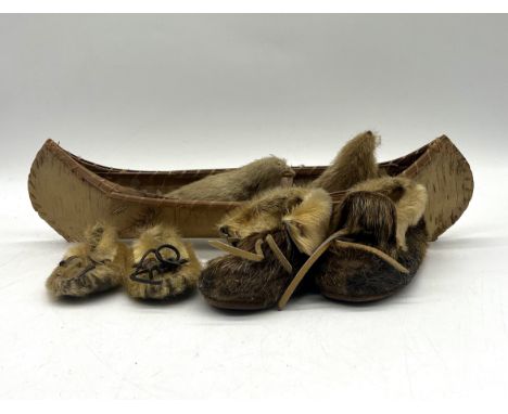 An assortment of tribal Inuit boots, animals and canoe  