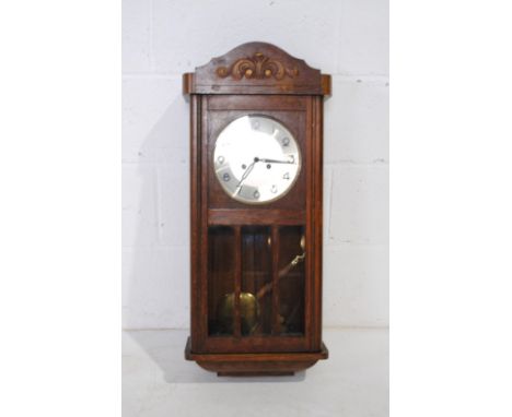 An Edwardian carved oak wall clock - length 34cm, height 77cm