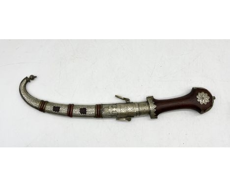 An Eastern Jambiya dagger with wooden grip and ornate scabbard 