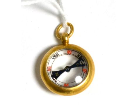 A compass charm stamped '18CT' 