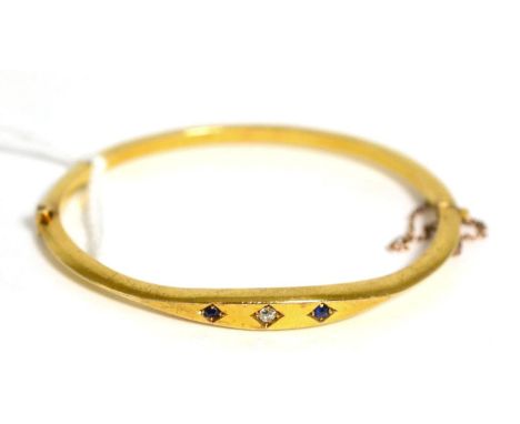 A diamond and sapphire bangle stamped '15CT' 