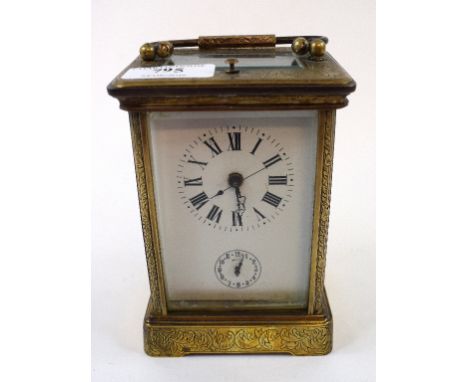 A carriage clock, with repeat, the white porcelain dial having Roman numerals and subsidiary seconds dial, in a four pillar b