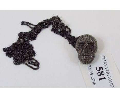 A silver skull pendant, set diamonds, on a chain