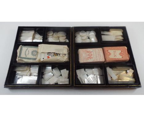 A pair of lacquer boxes, containing five smaller fitted boxes, containing a collection of mother of pearl gaming counters and