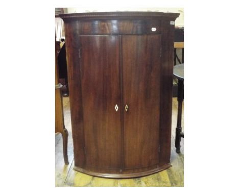 A George III bow front mahogany hanging corner cupboard, 78 cm wide