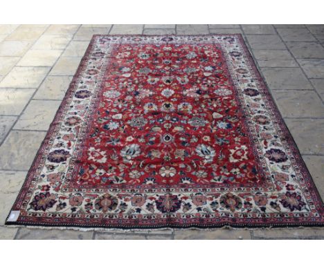 A European carpet, with floral motifs on a red ground, within a multi border, 294 x 198 cm 