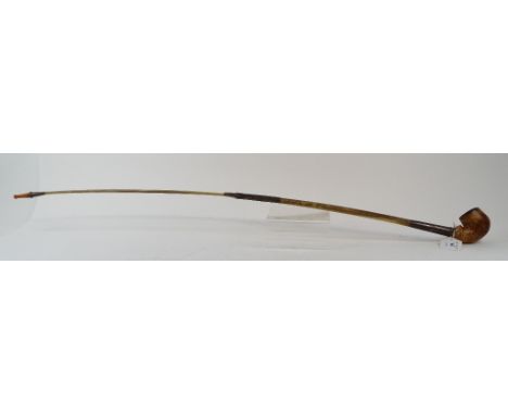 A 19th century silver coloured metal mounted pipe, with amber mouthpiece and bone neck, 80.5 cm