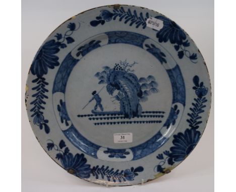 A Dutch Delft plate, decorated a figure hunting in a boat, 34 cm wide