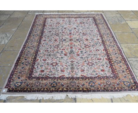 A Persian Tabriz carpet, with scrolling floral motifs on a cream ground, within a multi border, 287 x 194 cm