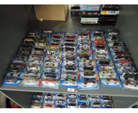 A shelf of Mattel Hot Wheels die-casts, 2002 period onwards, 70 in total, all on bubble display cards, all appear unopened