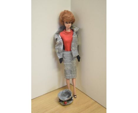 A 1959 Mattel Midge Barbie Doll having adjustable body wearing two piece grey suit with Barbie label, grey hat, red body suit