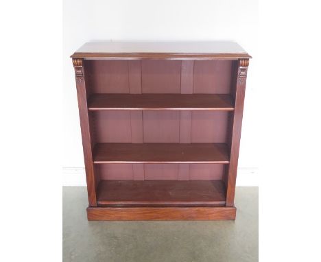 A Victorian mahogany open bookcase with two adjustable shelves and fixed base shelf with fine carved corbels supporting the t