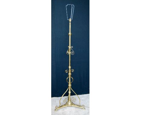Victorian tubular brass telescopic standard lamp on triform base and gadrooned bun feet.