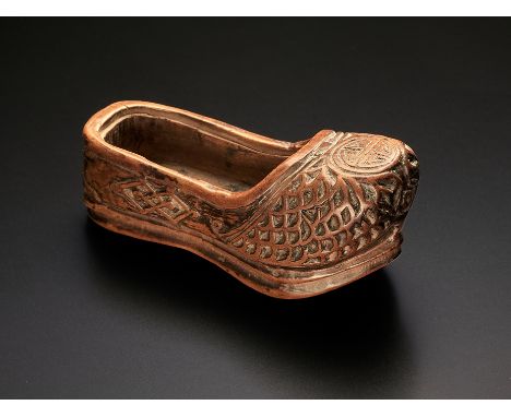 Netsuke. Schuh mit Zierreliefschnitzerei und Glückssymbol. Holz. Zentrales Himotoshi. 19. Jh. L 6,6 cm
