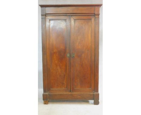 An antique French flame mahogany linen wardrobe with panel doors enclosing shelves on block feet. H.180 W.109 D.57cm 
