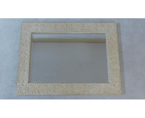 A vintage wall mirror in limed and carved frame fitted with bevelled plate. 122x92cm 