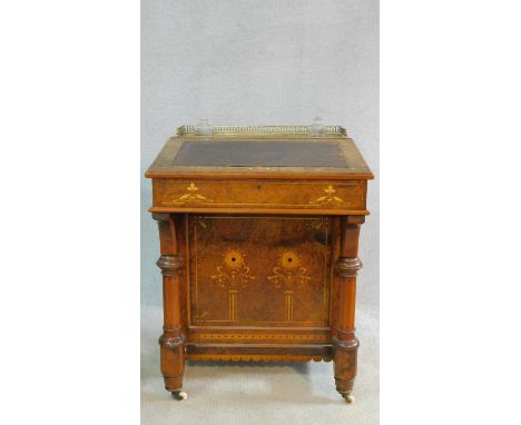 A late Victorian burr walnut Aesthetic style Davenport with satinwood floral Arabesque inlay and fitted interior above panel 