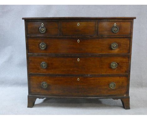 A late Georgian mahogany bowfronted chest of three short over three long drawers fitted with ivory escutcheons on swept brack