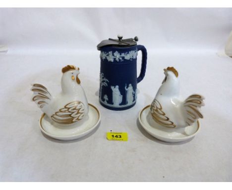 A Wedgwood blue jasperware water jug with pewter lid and a pair of royal Worcester egg cups with hen covers