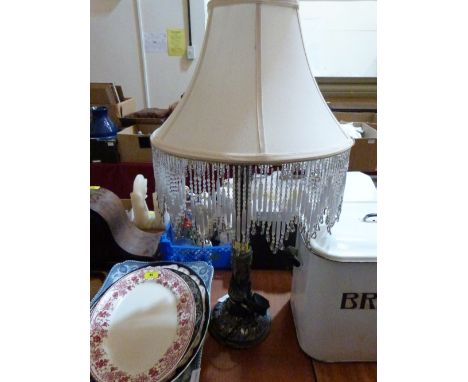 A table lamp with fabric and glass bead fringe shade