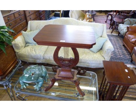 A reproduction carved hardwood lamp table raised on lyre form supports.