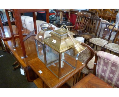 A decorative metal hanging lantern together with a stainless steel metal candle holder.