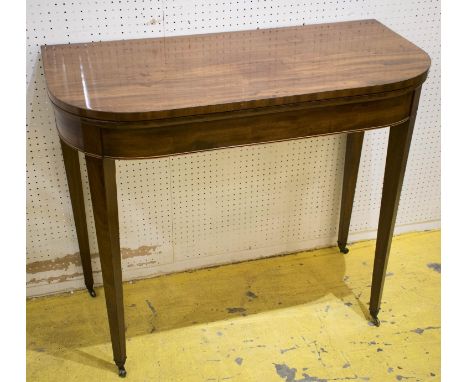 CARD TABLE, George III mahogany with hinged green baize D shaped top and brass castors, 78cm H x 91cm x 44cm. (slight losses)