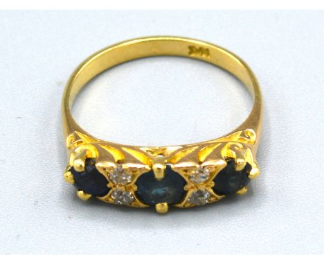 An 18ct. Gold Sapphire and Diamond Ring set with three sapphires and four diamonds, ring size O, 4.1 gms. 