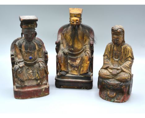 A Group Of Three Chinese Carved Hardwood And Gilded Seated Figures 22, 21 and 19 cms tall 