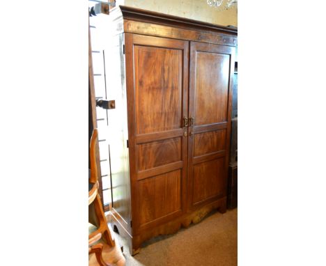 A 19th Century Mahogany Hall Cupboard, the moulded cornice above two panelled doors with line inlays above a shaped apron wit
