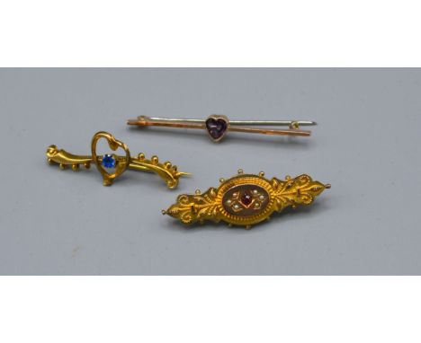 A 9ct Gold Amethyst Set Bar Brooch together with another similar 9ct gold bar brooch and a yellow metal bar brooch 