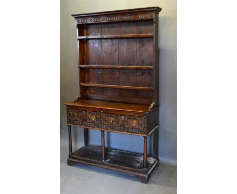 A George III Oak Dresser with a boarded shelf back above two moulded drawers with brass drop handles and escutcheons raised u